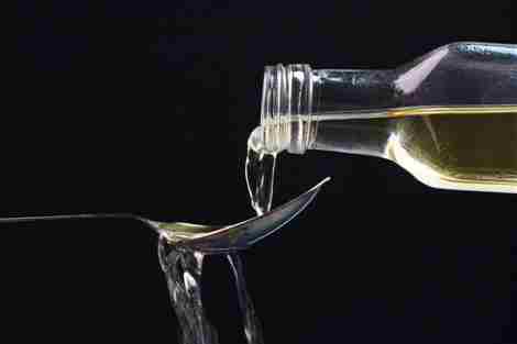 Proporcionado por CNET Una botella de vinagre de manzana vertiendo sobre una cuchara