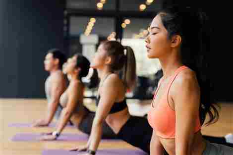 Mujeres jóvenes y hombres haciendo ejercicio en el gimnasio