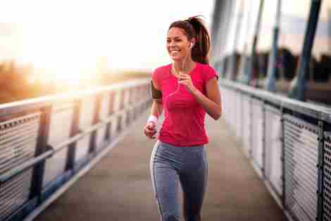 Mujer joven corriendo al aire libre en el puente.