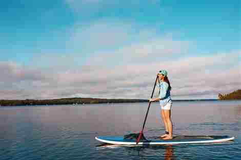 Foto de una mujer joven remando en un lago