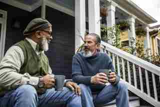 Proporcionado por Livestrong.com dos adultos mayores con barba tomando café mientras están sentados en las escaleras de una casa