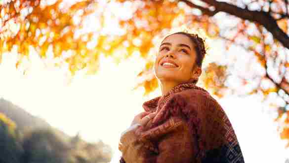 Hermosa joven disfrutando de un día de otoño sin preocupaciones al aire libre