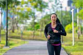 Adulto de mediana edad corriendo afuera para demostrar el ejercicio durante la menopausia.