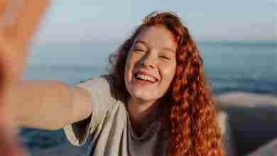 Chica sonriente con selfie de pelo rojo