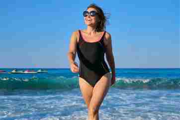 Mujer en traje de baño de una pieza en la playa.