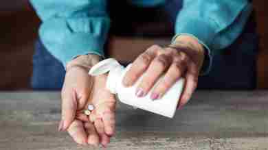 Mujer vaciando pastillas en su mano