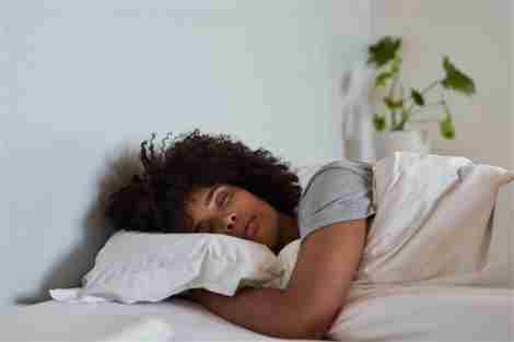 mujer durmiendo en su cama por la mañana