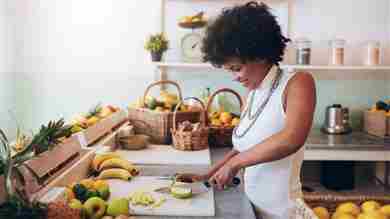 Mujer sonriente cortando fruta