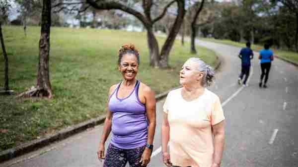 Dos mujeres maduras caminando por el parque para hacer ejercicio.